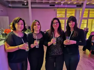 A vonósnégyes négy tagja koktéllal egy rózsaszín fényű rendezvényteremben