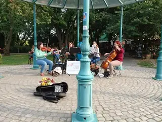 A vonósnégyes játszik egy türkiz oszlopos szabadtéri pavilonban