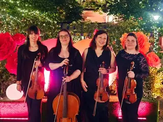 A vonósnégyes közelebbről, hangszerekkel a papírrózsák előtt